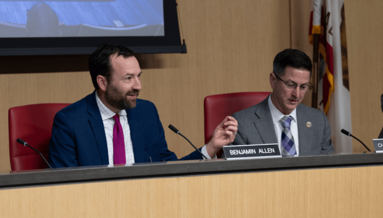 Senator Allen speaks from committee dias while chairing a joint information hearing.