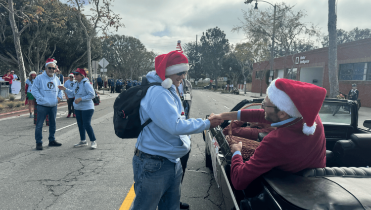Senator Allen shakes hands from a vehicle during parade