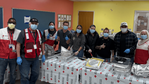 Staff pose while serving meals to neighbors in need